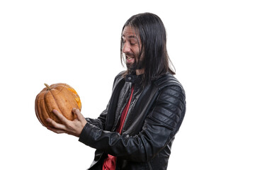 A man with a beard and long hair in a black jacket with a pumpkin in his hands posing on a white background. Various poses and emotions. Halloween concept. 