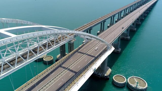 Beautiful suspension bridge over blue water. Shot. Highway on large suspension bridge passing through sea section. Crimean suspension bridge over turquoise water
