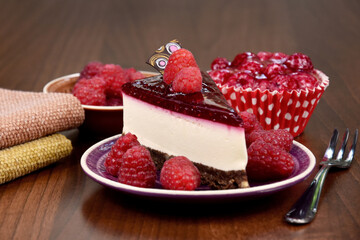 Delicious creamy raspberry cake on the table stock images. Slice of cheesecake with jelly topping and raspberries still life stock photo. Raspberry desserts on wooden background images