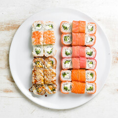 Asian cuisine. Large set of sushi rolls on a plate. Top view. On a white background.