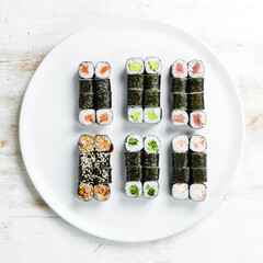 Traditional Japanese sushi rolls on a white plate. Top view. Asian food. On a white background.