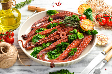 Baked octopus with spinach, lemon and parsley on a baking sheet. Top view. Flat lay.