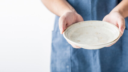 Male hands holding empty plate.
