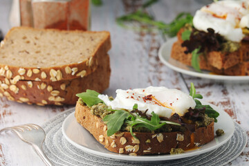 Homemade sandwiches with pesto, green salad and poached eggs