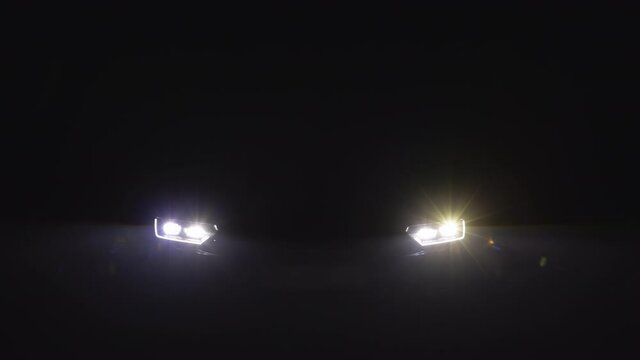 Close up of headlight turning on switching of car LED headlights in night. New modern car headlamp. Car Front Led Light with a Blurry Background