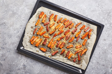 Sweet potato with cheese backed on baking sheet on grey background