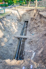 Excavated water pipes after replacement near the old house. Pipeline. Replacement of the pipeline.