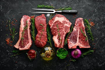 Variety of raw black Angus Prime meat steaks: t-bone, striploin, Rib eye, new york steak. Top view....
