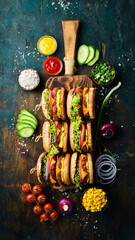 Homemade hamburger with fresh vegetables, meat and cheese. Top view. On a black stone background.