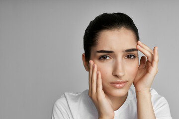 brunette with headache holding her head emotions migraine discontent