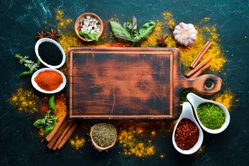 Poster Colorful herbs and spices for cooking. Indian spices. On a black stone background. Top view. © Yaruniv-Studio