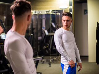 Fototapeta na wymiar Young Man Admiring His Muscles in Mirror