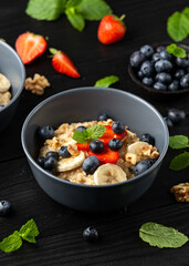 Healthy Oatmeal porridge breakfast with strawberry, blueberry, banana and honey