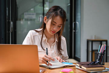 Portrait with businesswoman working at her office desk.