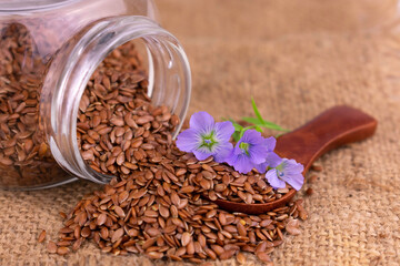 Fototapeta na wymiar Healthy flax seeds with flowers in a jar. Close-up.