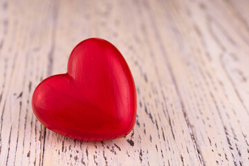 Red heart on wooden white background. Copy space.