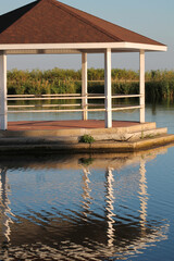Gazebo on the lake with its reflection on the water