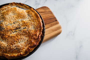 vegan baked savory pie with lentils and sesame and poppy seeds topping, healthy plant-based food
