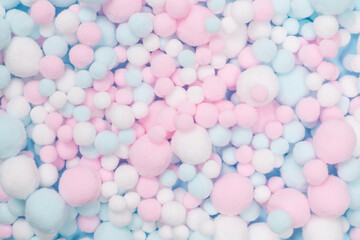 White, pink and blue soft pompons as a background.