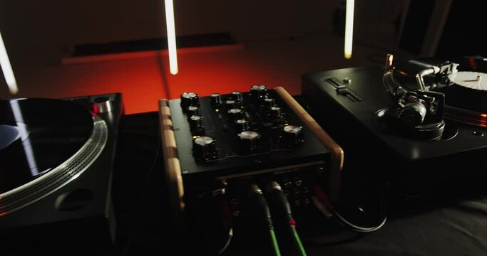 Deejay turntable in darkness in nightclub. Close-up of dj musical record player with spinning records. Music on party