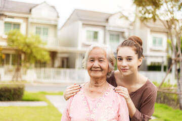 Happy elderly woman with a caregiver in the garden, Home care concept...