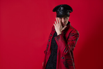 Fototapeta premium An outrageous young man in a daring red coat in a vintage noir style,