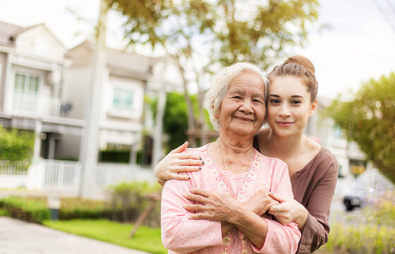 Happy elderly woman with a caregiver in the garden, Home care concept...