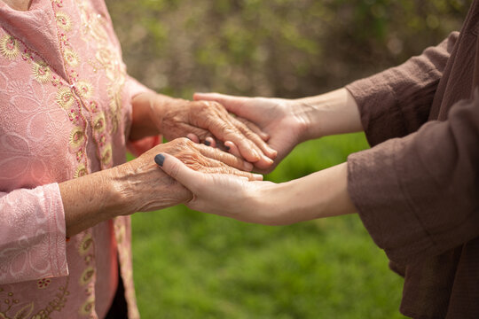 Hand of eldery woman with her caregiver at home. Home care or Elderly care concept.