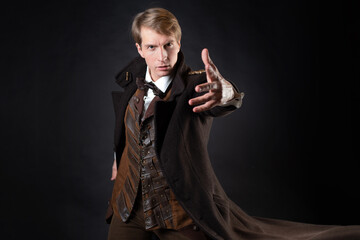 character of the steampunk story, a young attractive man in an elegant long coat - 448361574