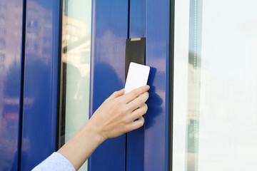 Woman opening magnetic door lock with key card outdoors, closeup