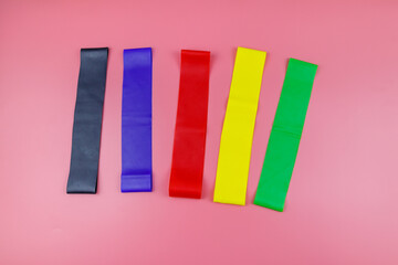 Set of elastic rubber bands for fitness on a pink background. Top view