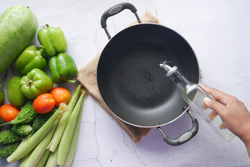 Pouring vegetable oil into frying pan. top view 