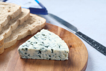  blue cheese ,and slice of brown bread on table 