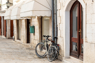 Fototapeta na wymiar Bikes parked near building at the street of city.
