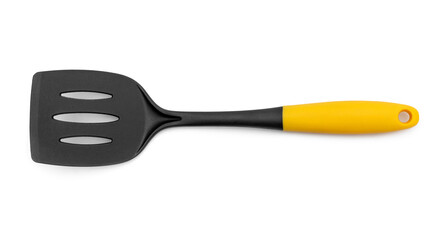 Black plastic spade with a yellow handle for frying pan on white background.