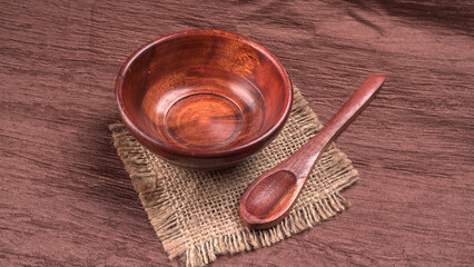 Empty wooden bowl and wooden spoon isolated with copy space.