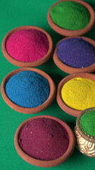 Diwali Festival showing Colourful rangoli in bowls,clay lamp or diya on background