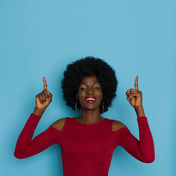 Young Black Woman In Red Top Is Pointing Up