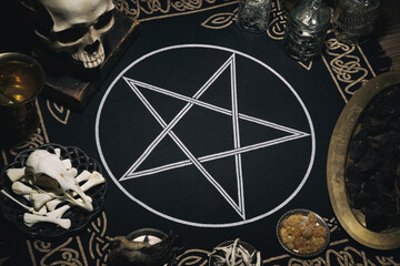 Witchcraft flta lay composition with human skull, bones, herbs and pentagram symbol. Halloween and...