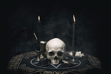 Witchcraft composition with burning candles, human skull, bones, herbs and pentagram symbol. Halloween and occult concept, black magic ritual.  - 448372151