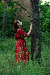 Save and Plant Trees, Save Earth and Nature, Stand For Trees, Save Forests and Heal the Climate. Woman in a red dress walking in forest, hugging trees and touching the trunks