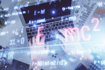 Double exposure of man's hands typing over computer keyboard and formula hologram drawing. Top view. Education concept.