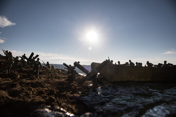 Fototapeta premium World War 2 reenactment (D-day). Creative decoration with toy soldiers, landing crafts and hedgehogs. Battle scene of Normandy landing on June 6, 1944.