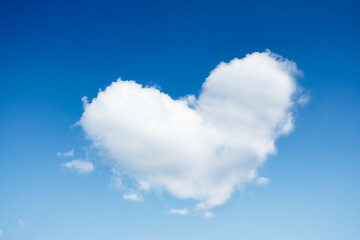 Obraz na płótnie Canvas A cloud in the shape of a heart. A blue sky and a heart sign. Romance and love. High resolution photo as wallpaper.