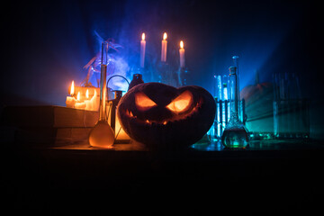 Halloween still-life background with different elements on dark toned foggy background. Selective focus