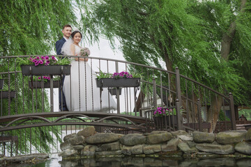 Fototapeta premium Portrait of an international loving couple of newlyweds against the backdrop of nature and flowers