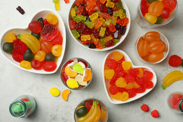 Delicious gummy candies on light grey table, flat lay
