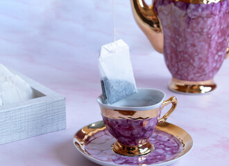 tea bag dipping into a cup of hot water