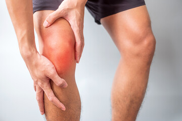 man with muscle pain on grey background. Elderly have knee ache due to Runners Knee or...