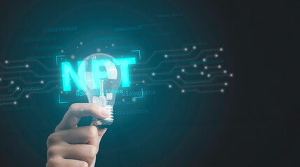 NFT non fungible tokens concept. Hand holding light bulb idea creativity with digital unique art NFT hologram on circuit board